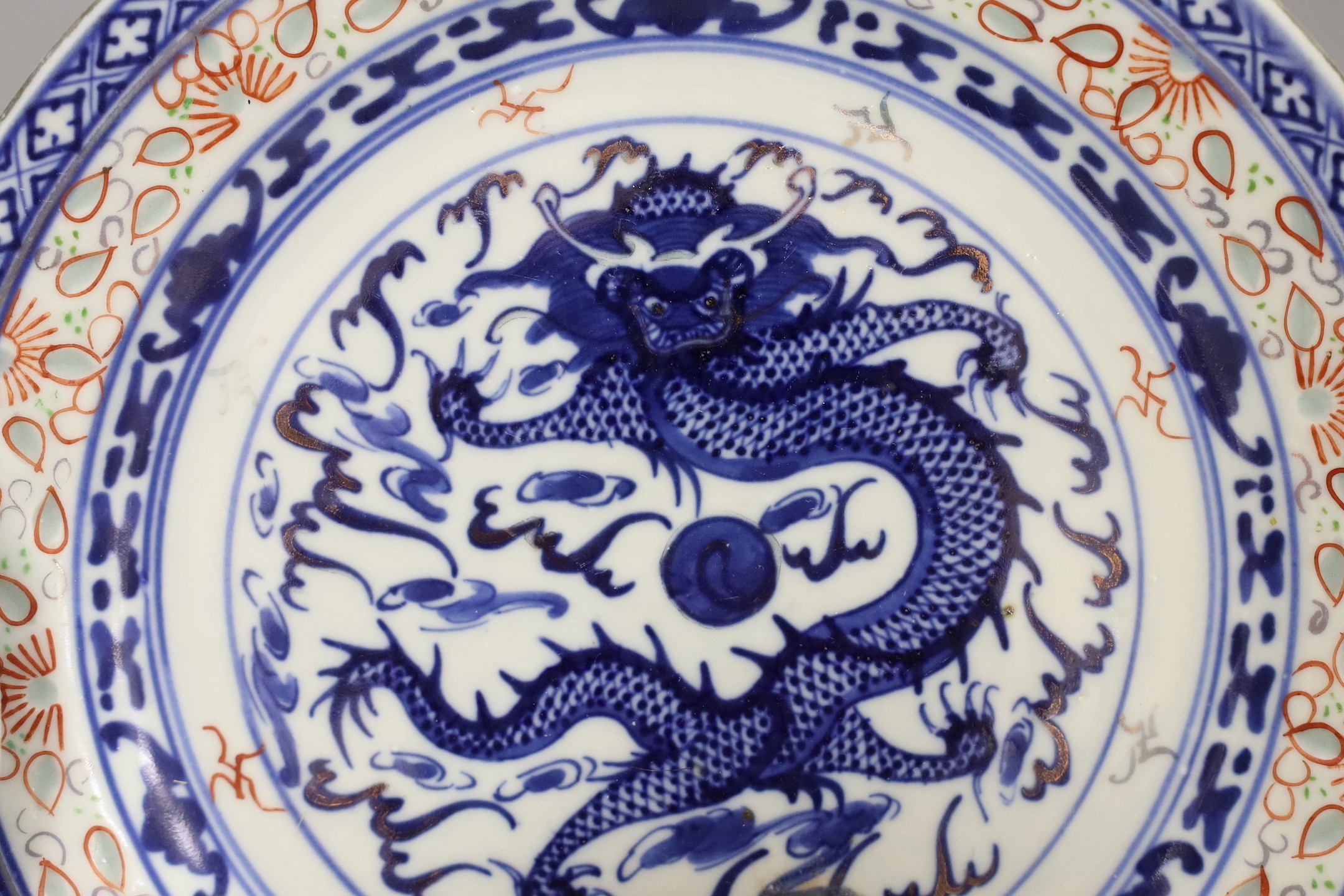 A Chinese blue and white ’dragon’ dish and similar plate, plate 20 cms diameter.